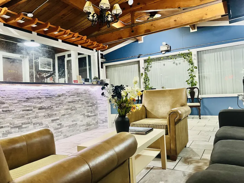 Warm timber-ceilinged lobby with leather armchairs and a stone wall