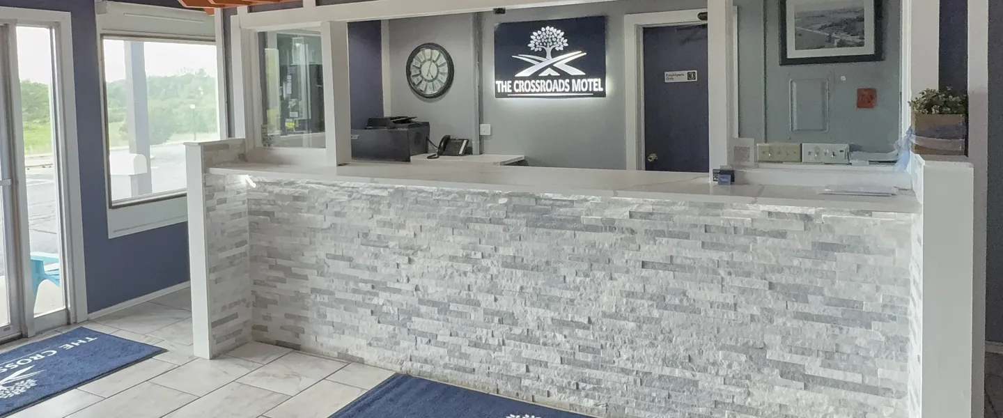 Warm timber-ceilinged lobby with leather armchairs and a stone feature wall