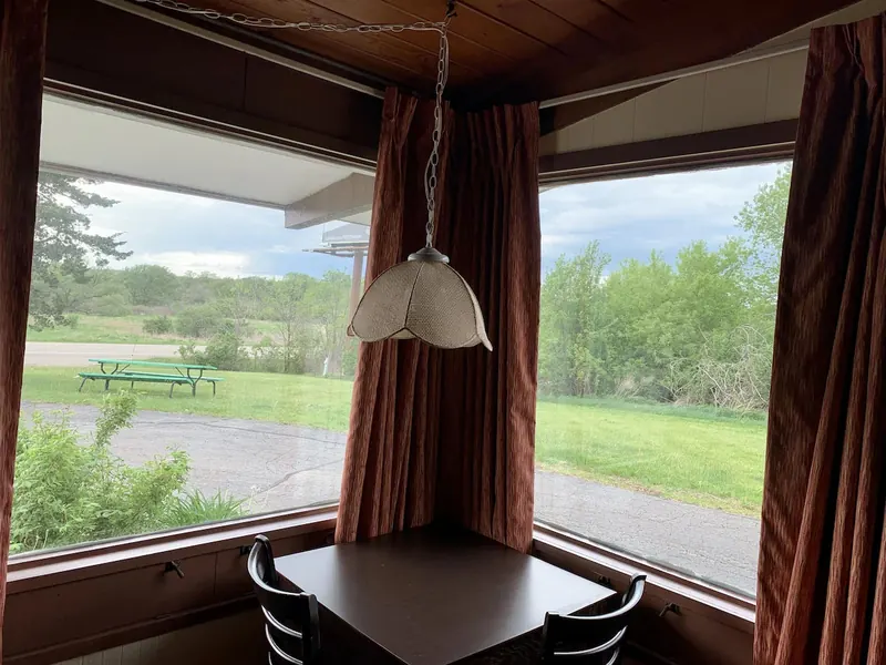 Corner window looking out across green fields from a room