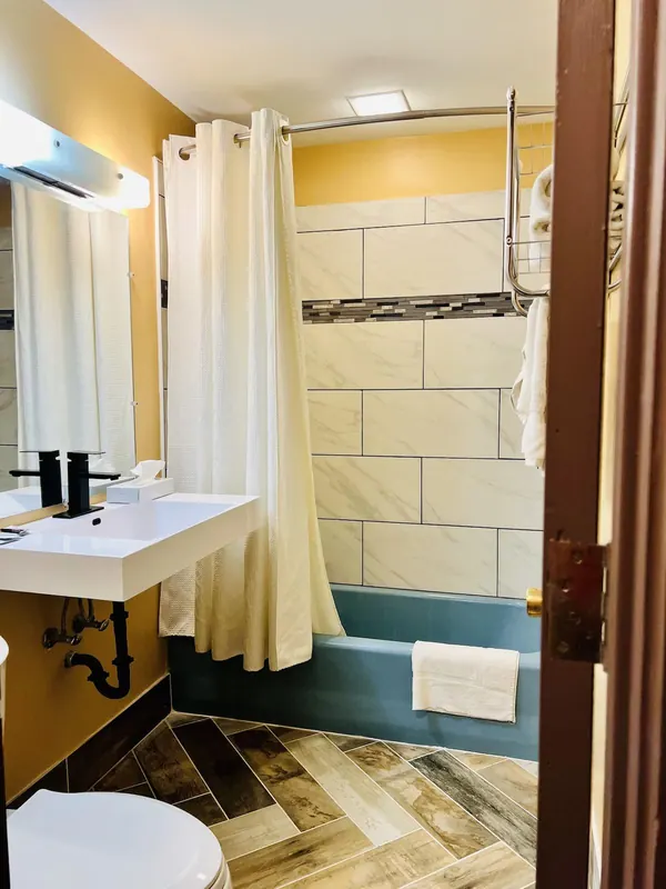 Bathroom with tiled tub and shower curtain